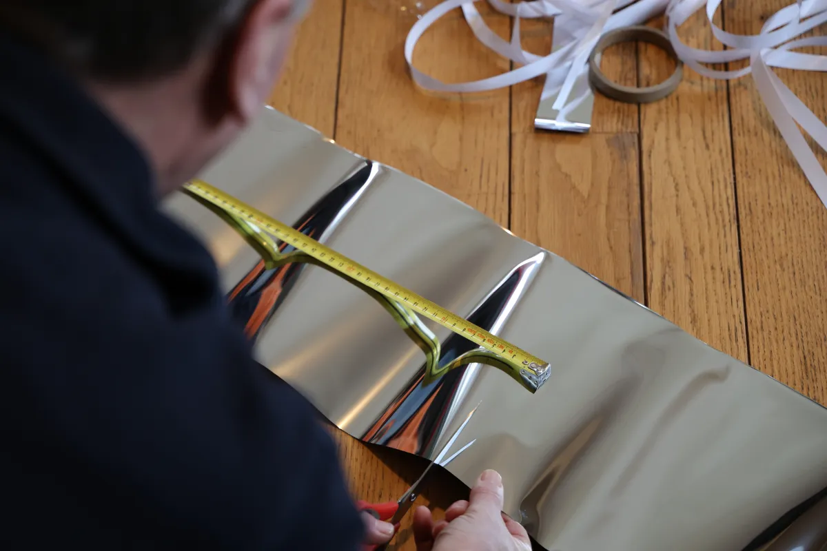 Energiefixer meet en knipt radiatorfolie om warmteverlies te verminderen en energiebesparing te bevorderen.